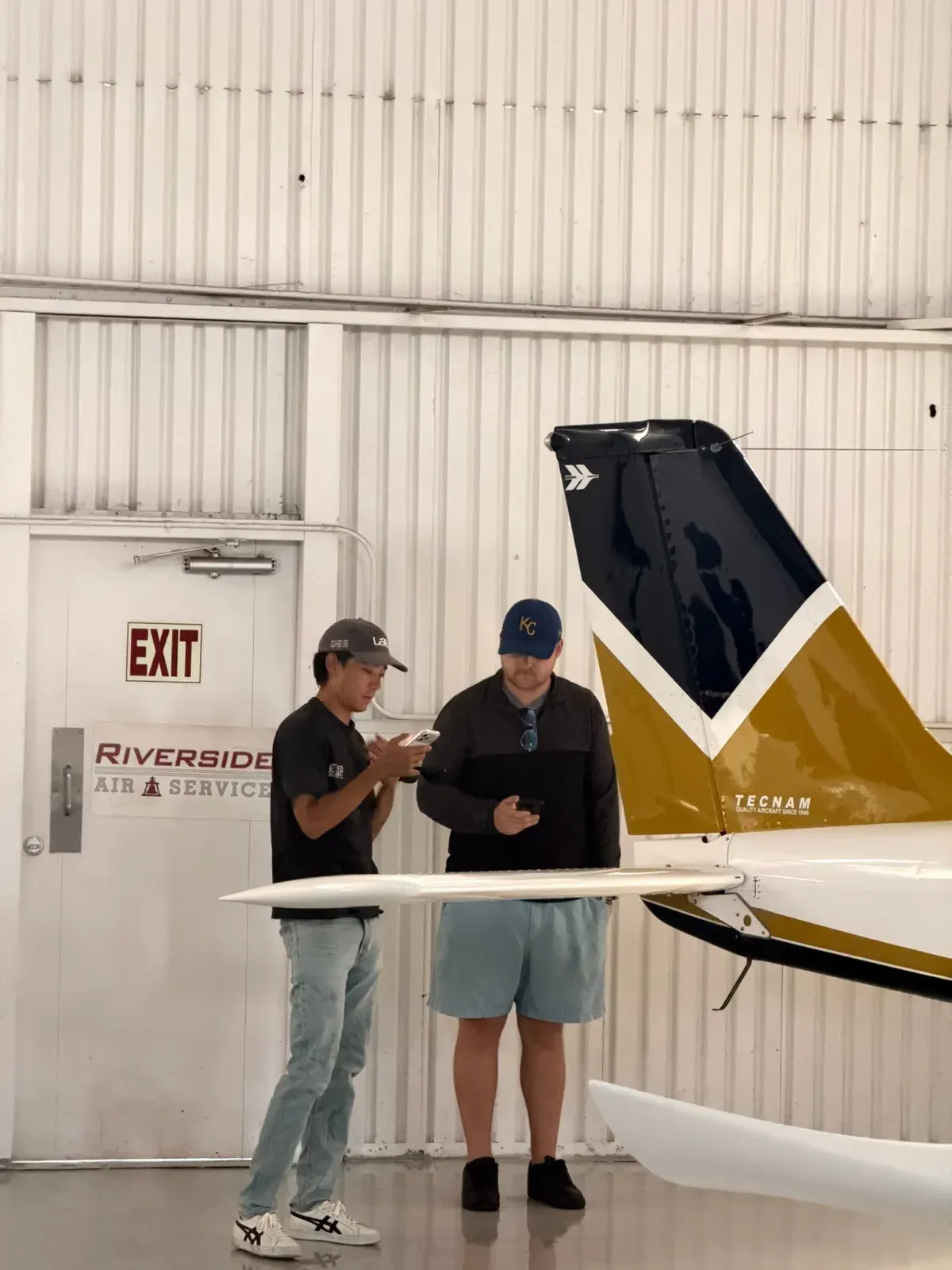 Students beside the tail of a CFII trainer in the hangar