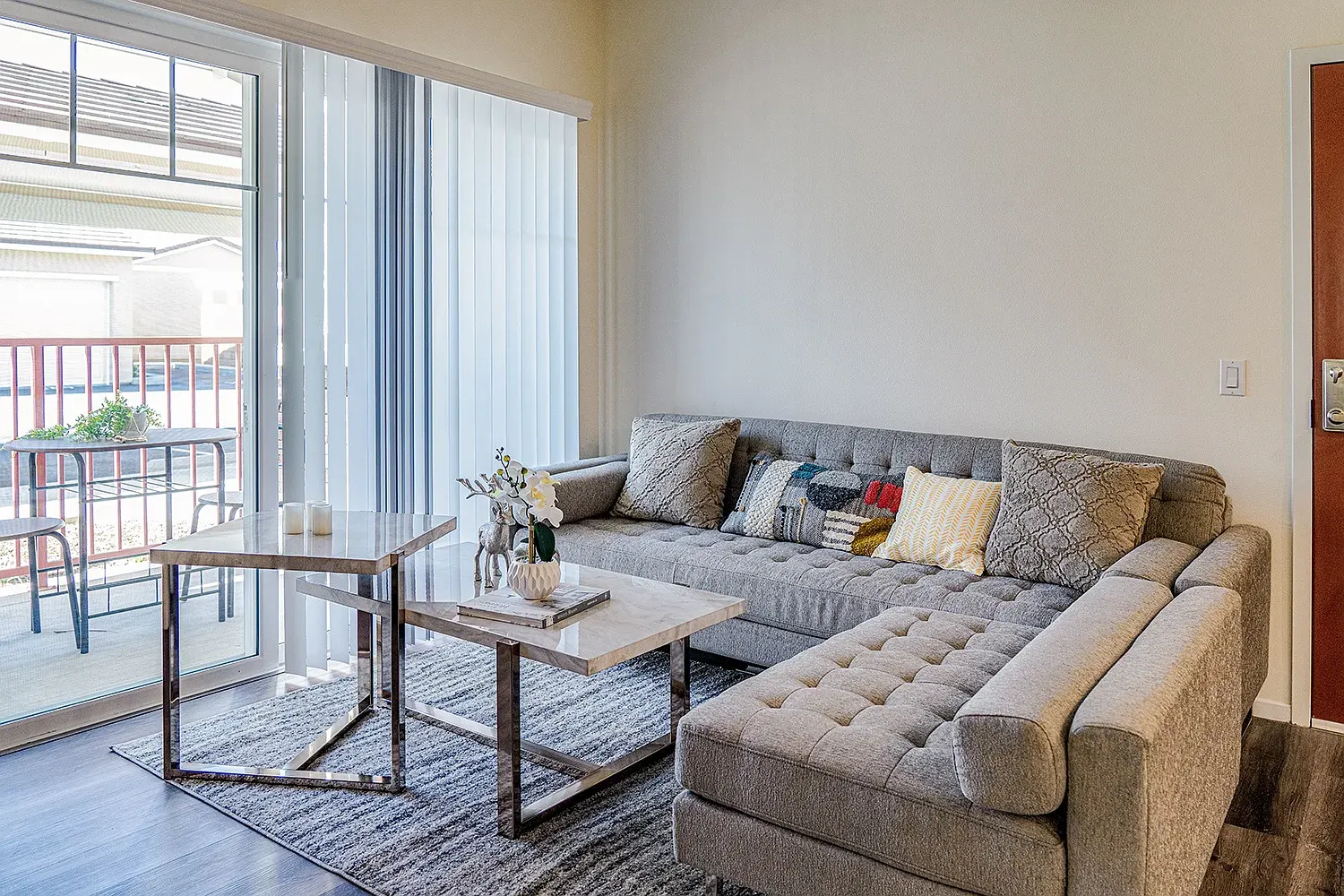 The living room of a furnished student apartment near our Riverside base, with a sliding door to a balcony