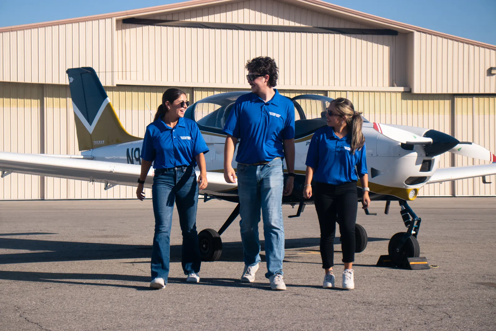 Three CFII students walking away from a P-Mentor on the ramp at Riverside